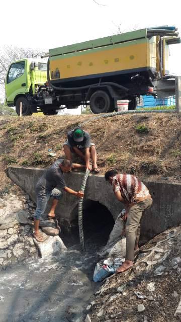 sejumlah petugas tengah berupaya keras untuk menyedot limbah cair